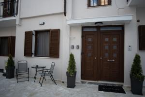 a wooden door in a building with chairs and a table at Kastrino Luxury Studio in Ioannina