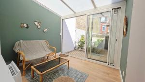 a living room with a chair and a window at l'Eclat Malouin - Parking & Garden in Dunkerque