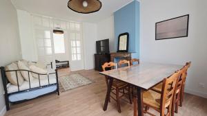 a dining room with a table and a couch at l'Eclat Malouin - Parking & Garden in Dunkerque