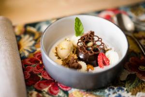 a small white bowl filled with desserts on a table at Mirabell Dolomites Hotel in Valdaora