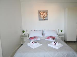 ein weißes Schlafzimmer mit einem weißen Bett und Kissen in der Unterkunft Casa Solari Rapallo in Rapallo