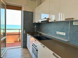 una cucina con lavandino e vista sull'oceano di Sogno Vista Mare - Novità! Vicina alla Rotonda e con Parcheggio Privato a Senigallia