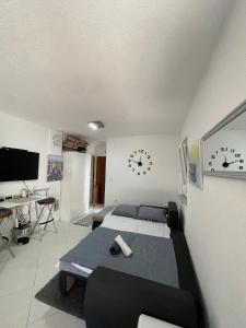 a room with two beds and a desk and clocks on the wall at Seaesta holiday- Modern studio in Okrug Gornji