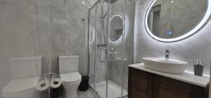 une salle de bain avec un lavabo, des toilettes et un miroir dans l'établissement Seaside Loft, à Marsalforn