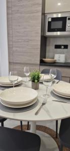 - une table blanche avec des assiettes et des verres à vin dans l'établissement Seaside Loft, à Marsalforn