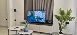 - un salon avec deux tables et une télévision à écran plat dans l'établissement Seaside Loft, à Marsalforn