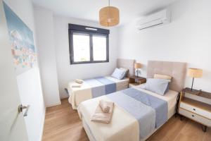 a bedroom with two beds and a window at Gandia Playa Moderna - nuevo con piscina y parking, 2 banos, playa 300 m, grau 300 m in Playa de Gandia