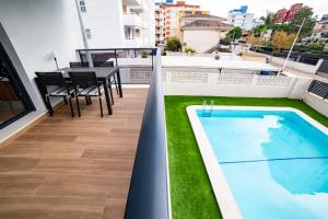 a balcony with a swimming pool and a table at Gandia Playa Moderna - nuevo con piscina y parking, 2 banos, playa 300 m, grau 300 m in Playa de Gandia