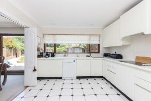 a kitchen with white cabinets and a window at Moongate in Christchurch