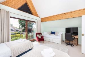 a bedroom with a bed and a desk and a window at Moongate in Christchurch
