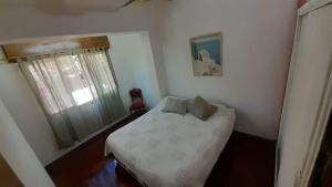 Un dormitorio pequeño con una cama y una ventana. en Luceros, en Mendoza