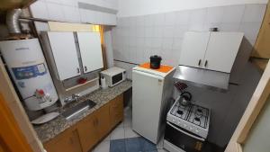 Una pequeña cocina con fregadero y refrigerador. en Luceros, en Mendoza