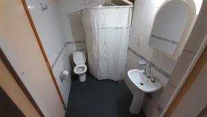 Un baño con lavabo, inodoro y espejo. en Luceros, en Mendoza