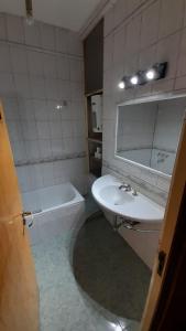 Un baño con lavabo, espejo y bañera. en Luceros, en Mendoza