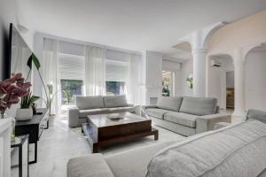 a living room with two couches and a table at Stunning 5 Bedroom Villa in Puerto Banus with Pool in Marbella