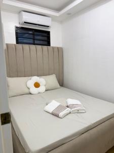 a bed with two towels and a stuffed flower on it at suite dreams in Bangad