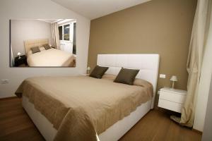 une chambre avec un lit avec un miroir au mur dans l'établissement Residence La Villa Tignale, à Tignale 46 autres photos