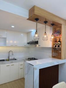 a kitchen with white cabinets and a counter with lights at suite dreams in Bangad +4 photos