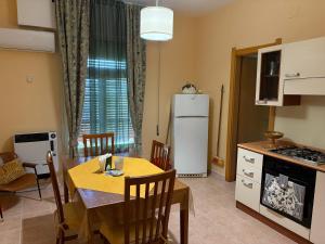 a kitchen and dining room with a table and a refrigerator at Residence Praetorium Maiella Park in Pretoro