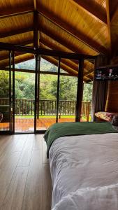 a bedroom with a bed and a view of a porch at Entre Árboles Lodge in San Gerardo de Dota