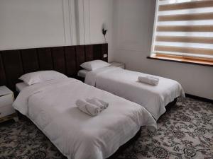 two beds in a room with towels on them at Fam Guest House in Samarkand