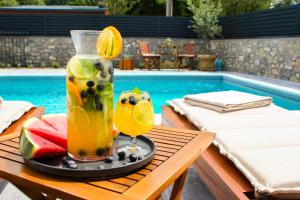a drink on a table next to a pool at Villa Aurelia Wellness Bihać in Bihać