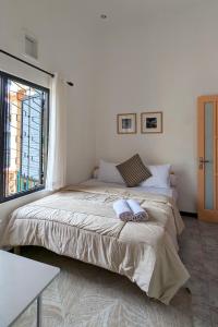 a bedroom with a large bed with two towels on it at Casa de Vie Homestay in Malang
