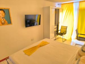 een slaapkamer met een bed met een gele servet erop bij Boutique Hotel Principal ,Tarrafal in Tarrafal