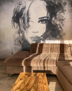 a living room with a couch and a mural at KOA - Moon Penthouse in Braşov
