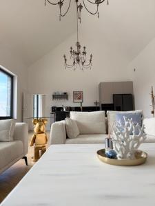 un salon avec un canapé et un lustre dans l'établissement Villa IBIZA, à Śmiechów