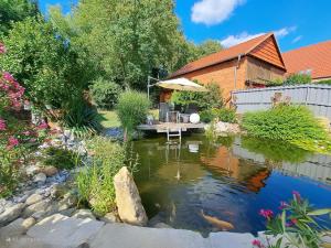 a garden with a koi pond in front of a house at Meine Ferienwohnung Seeburg 1 in Seeburg