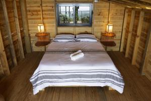 a large bed in a wooden room with two lamps at Casa Loma, Descansar en la Montaña, 30min STG in La Búcara +46 photos