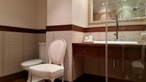 a bathroom with a chair and a sink and a toilet at Apartament przy Ziołowej in Augustów