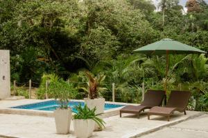 two chairs and an umbrella next to a swimming pool at Casa Loma, Descansar en la Montaña, 30min STG in La Búcara