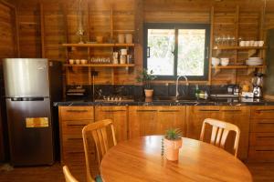 a kitchen with a wooden table and a refrigerator at Casa Loma, Descansar en la Montaña, 30min STG in La Búcara