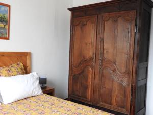 1 dormitorio con un gran armario de madera junto a una cama en Le gîte du forgeron, en La Tour-dʼAigues 10 fotos más
