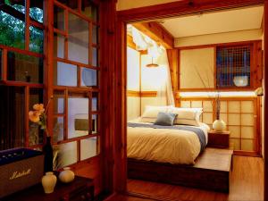 a bedroom with a bed in a room with windows at #오픈할인# 경복궁역 도보 4분#한옥#전통체험#경복궁,인사동,북촌,서촌,광화문,명동, 동대문 바로 옆#짐보관# 9인#호텔침구#각방에어컨#무료와이파이#세탁건조기#교통최고 in Seoul +40 photos