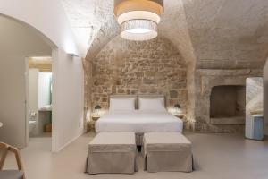 ein Schlafzimmer mit einem Bett und einer Steinwand in der Unterkunft Arco Vecchio Urban Suite - Epoca Collection in Lecce + 57 Fotos