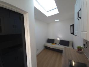 a white living room with a couch and a skylight at Chic Cosy - 10m2 Home in CR7 in Thornton Heath