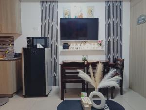 a living room with a table and chairs and a television at AA's Property in Sampong