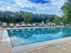 a large swimming pool with chairs and blue water at Hotel Csillag Tokaj in Tokaj