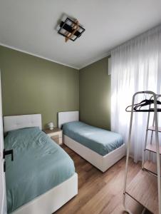 a bedroom with two beds and a window and a ladder at LAGUNA BLU - Villa da sogno con idromassaggio panoramico sul Lago di Como in Colico +91 photos
