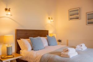 a bedroom with a bed with towels on it at The Pilot's Cottage in Cornamucklagh