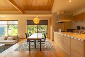 Una cocina y una sala de estar con mesa y sillas. en 癒しの宿 古紗庵, en Minakami