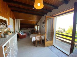 a living room with a table and a glass door at Appartement vue lac in Publier