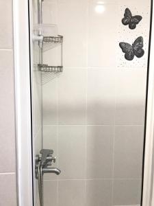two butterflies are on the wall of a shower at Günaydın Apart&House in Ortaca