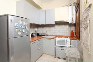 a kitchen with white cabinets and a stainless steel refrigerator at The Blue Horizon House in Afitos