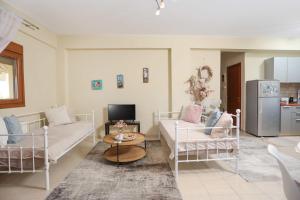 a living room with two beds and a couch at The Blue Horizon House in Afitos +17 photos