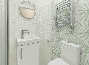 a bathroom with a toilet and a sink and a mirror at Spacious House with Garden in London +11 photos