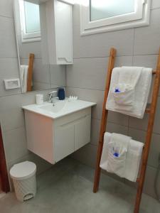 ein Badezimmer mit Waschbecken, Toilette und Spiegel in der Unterkunft Villa Majorelle à Tezdaine in Djerba